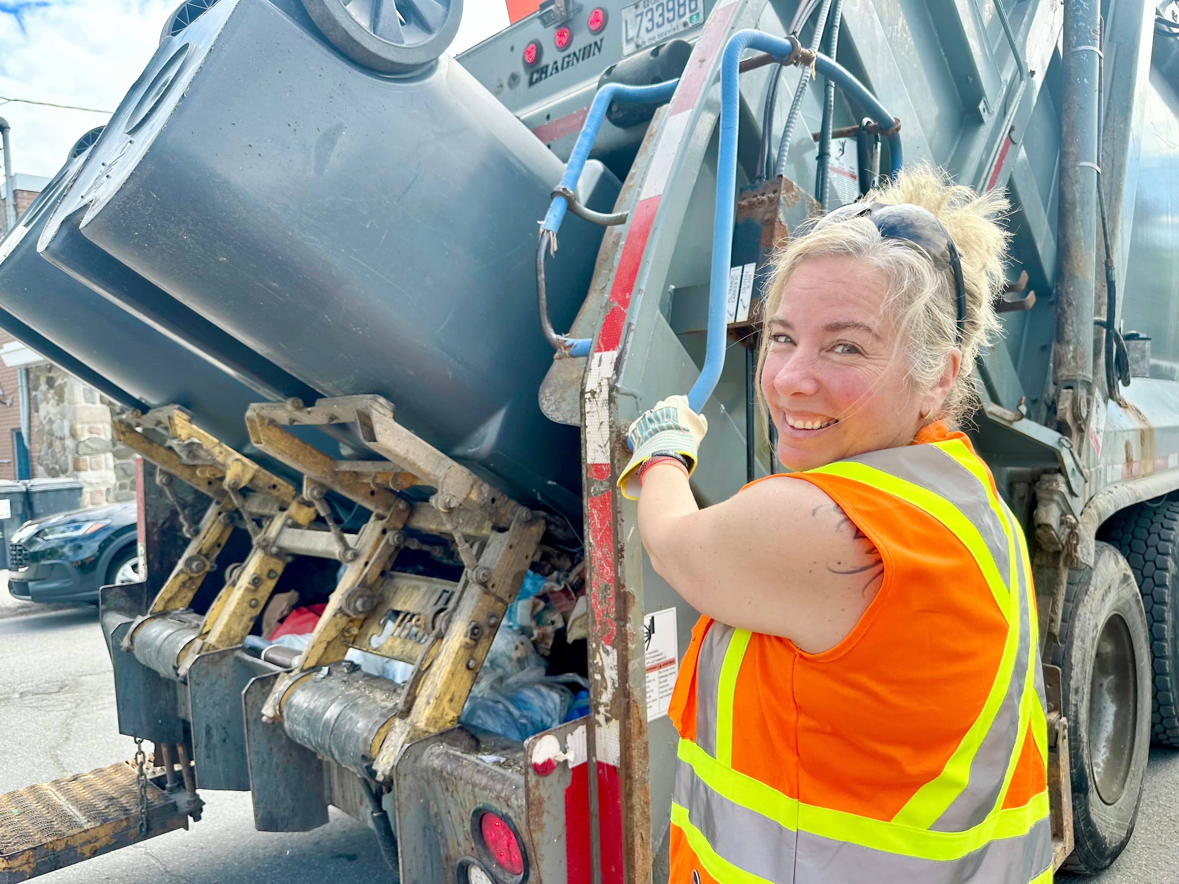 L'éboueuse émérite Caroline Gougeon me montre comment manipuler le levier du lève-bacs.