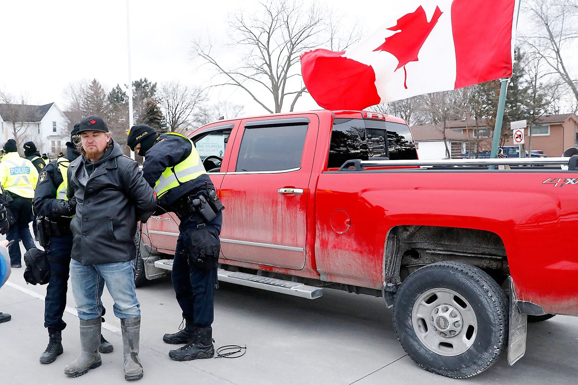 Les policiers ont passé les menottes à une vingtaine de protestataires à Windsor, dont cet homme qui refusait de quitter les lieux du blocus à côté du pont Ambassador, qui a finalement été démantelé.
