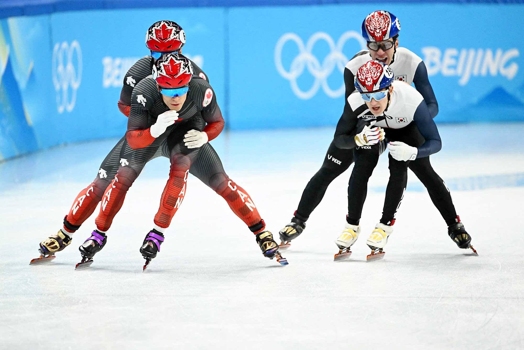 Jordan Pierre-Gilles qui reçoit une poussée de Charles Hamelin pendant la finale du relais 5000 m de patinage de vitesse sur courte piste mercredi à Pékin. À leur côté, Hwang Dae-heon et Park Jang-hyuk de la Corée du Sud.