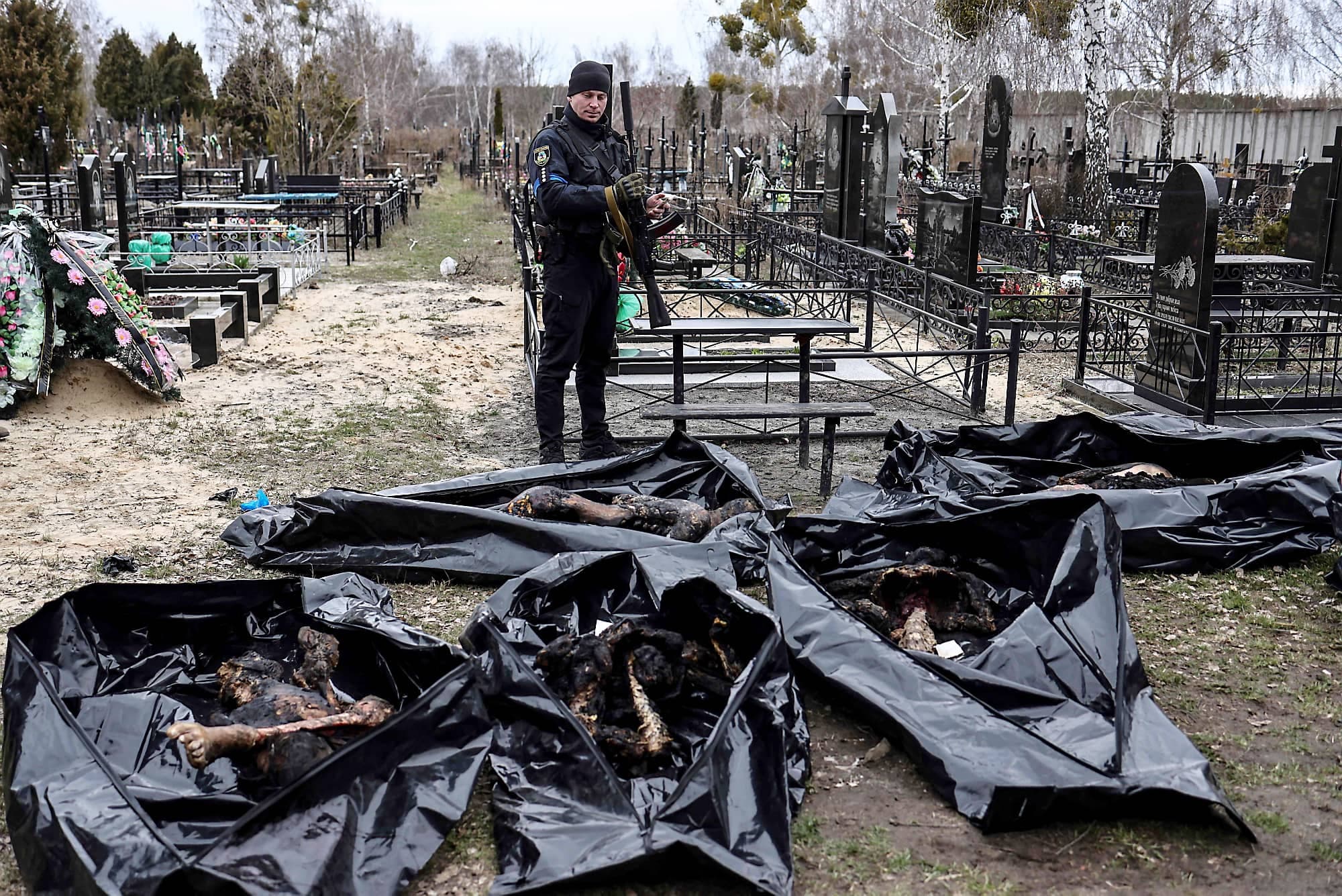 Des sacs mortuaires sont alignés pour l’identification de victimes par du personnel médico-légal et des policiers dans le cimetière de Boutcha, au nord de Kyïv.
