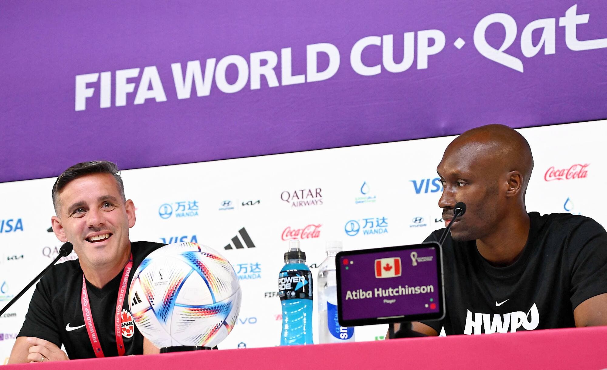 John Herdman (à gauche) avait retrouvé le sourire après être arrivé en retard à une conférence de presse, mardi, en compagnie du milieu de terrain Atiba Hutchinson.