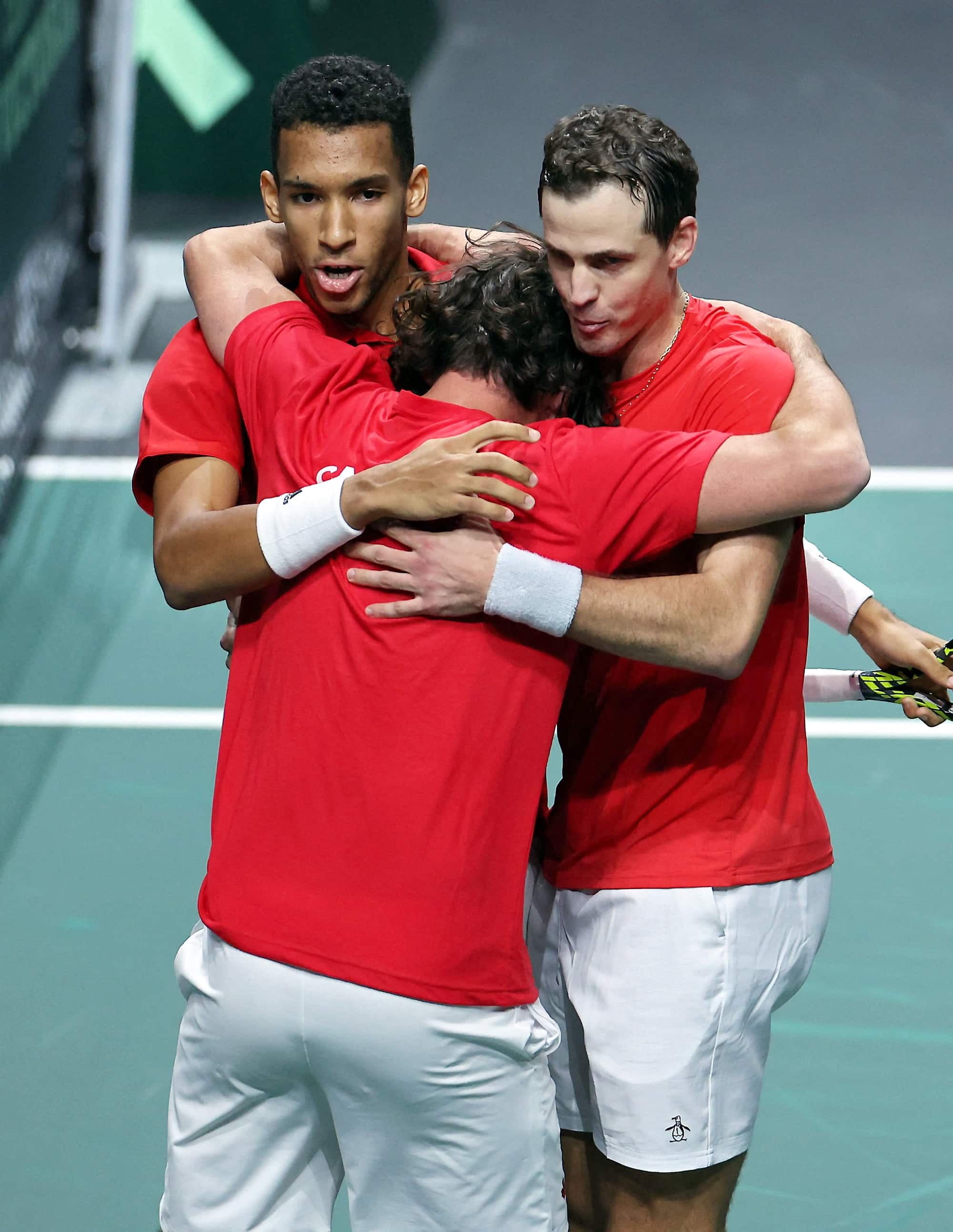 Félix Auger-Aliassime et Vasek Pospisil enlacent le capitaine Frank Dancevic après avoir assuré leur place en finale, samedi.