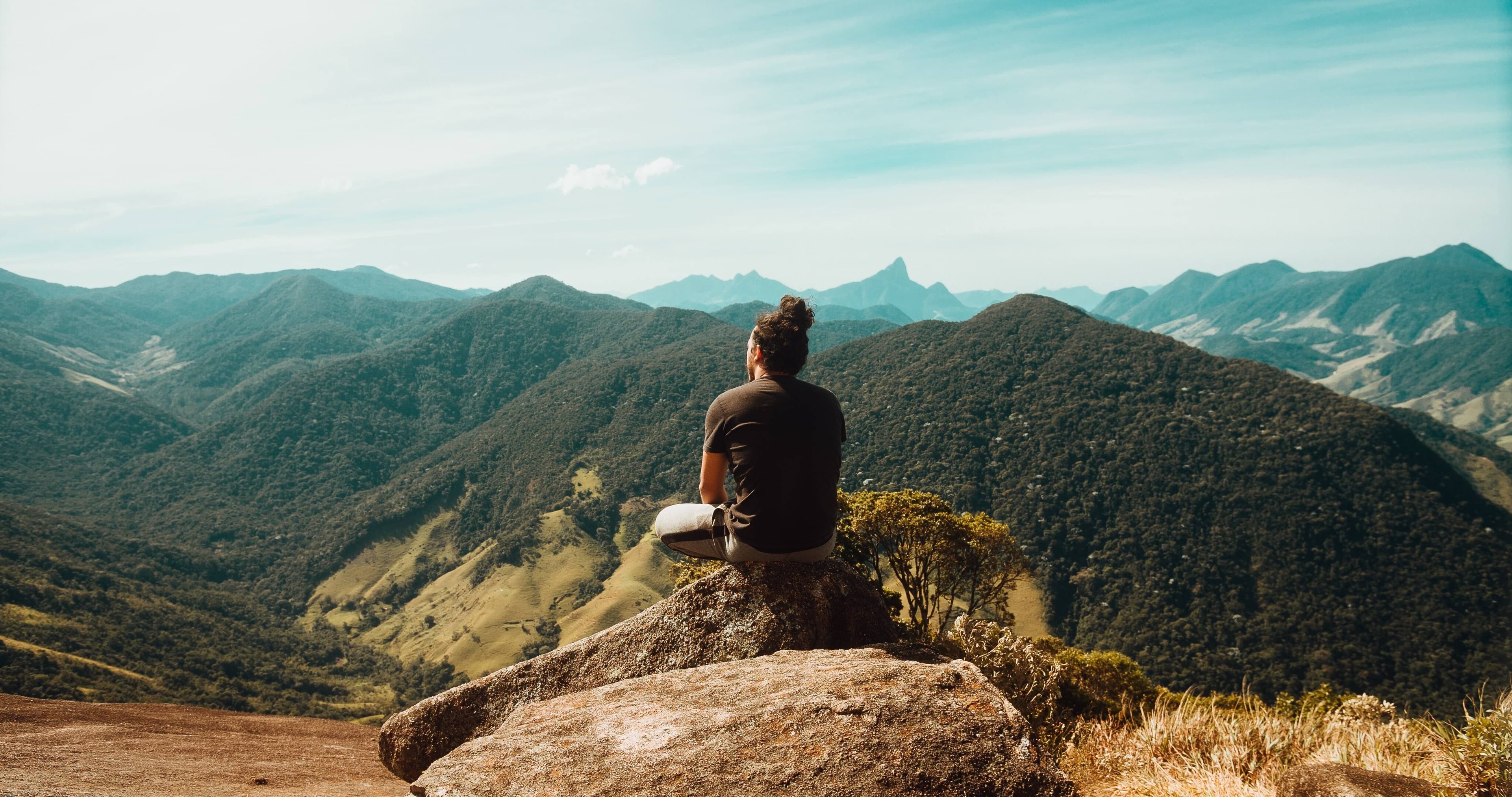 Une personne assise au sommet des montagnes de la forêt atlantique à Rio de Janeiro