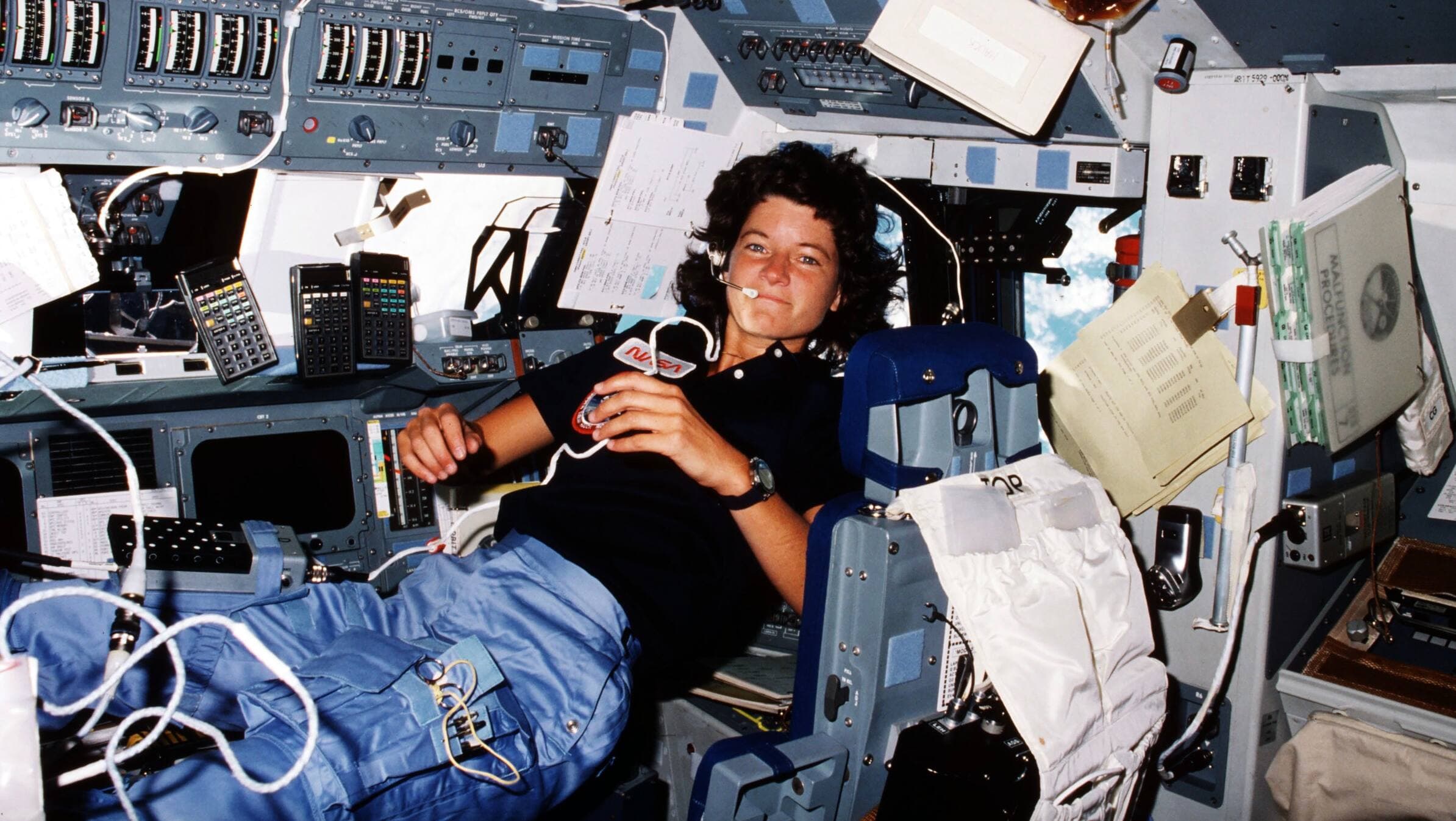 Sally Ride, première femme américaine à aller dans l'espace, sur le poste de pilotage lors de la mission STS-7 de la navette spatiale Challenger, juin 1983.