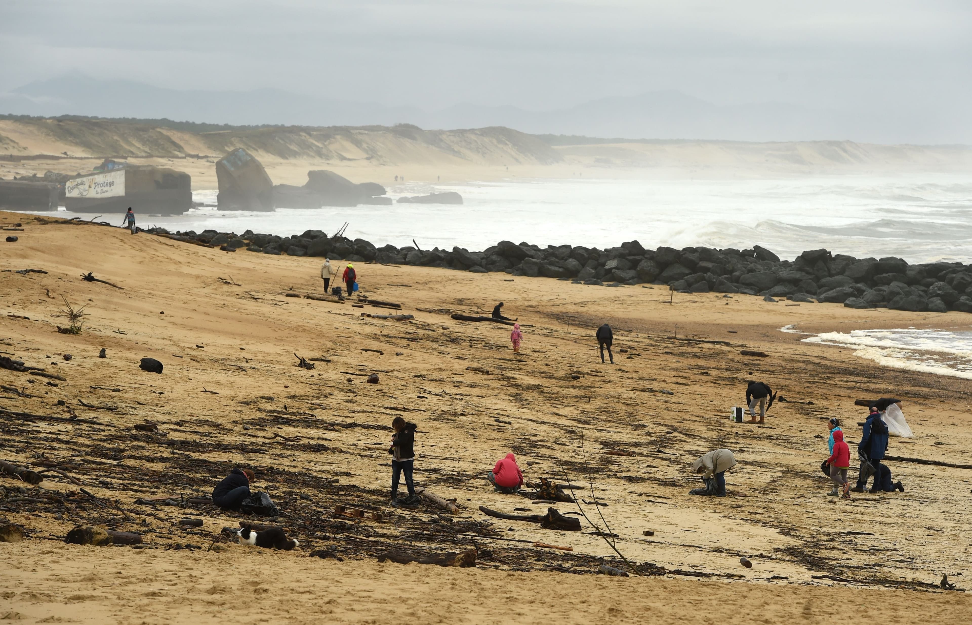 Des gens recherchent des ballots de cocaïne échoués sur la plage de Cap Breton, en France.