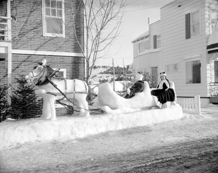 La reine du Carnaval de Sainte-Agathe-des-Monts 1961 assise dans une sculpture de neige en forme de calèche. Le cheval porte un vrai harnais! BAnQ, E6,S7,SS1,D229490-229499.