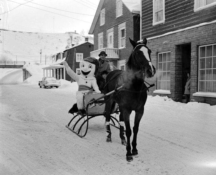 Balade en traîneau pendant le carnaval d’hiver de Saint-Raymond de Portneuf vers 1955. La buée produite par l’haleine du cheval, bien visible sur la photo, semble indiquer qu’il fait très froid! BAnQ, P322,S3,D4-32.