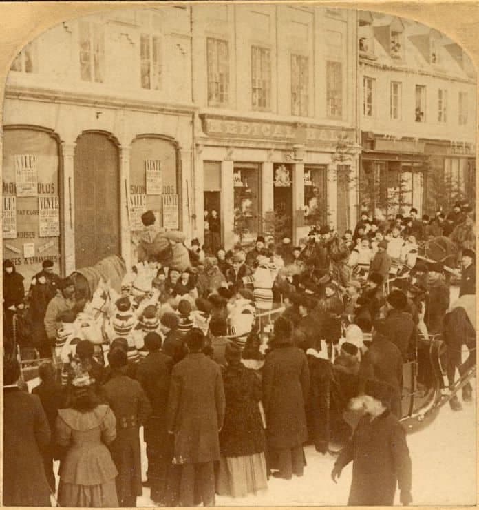 Parade du Carnaval de Québec sur la côte de la Fabrique en 1894. On aperçoit le char allégorique du Club des raquetteurs devant le magasin The Medical Hall. BAnQ, P1000,S4,D66,P11.