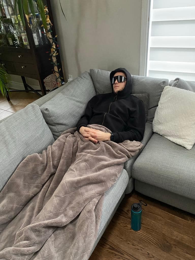 Ludovic Bégin passe ses journées étendu en raison de la COVID longue durée. Il porte des lunettes de soleil, car il est intolérant à la lumière.