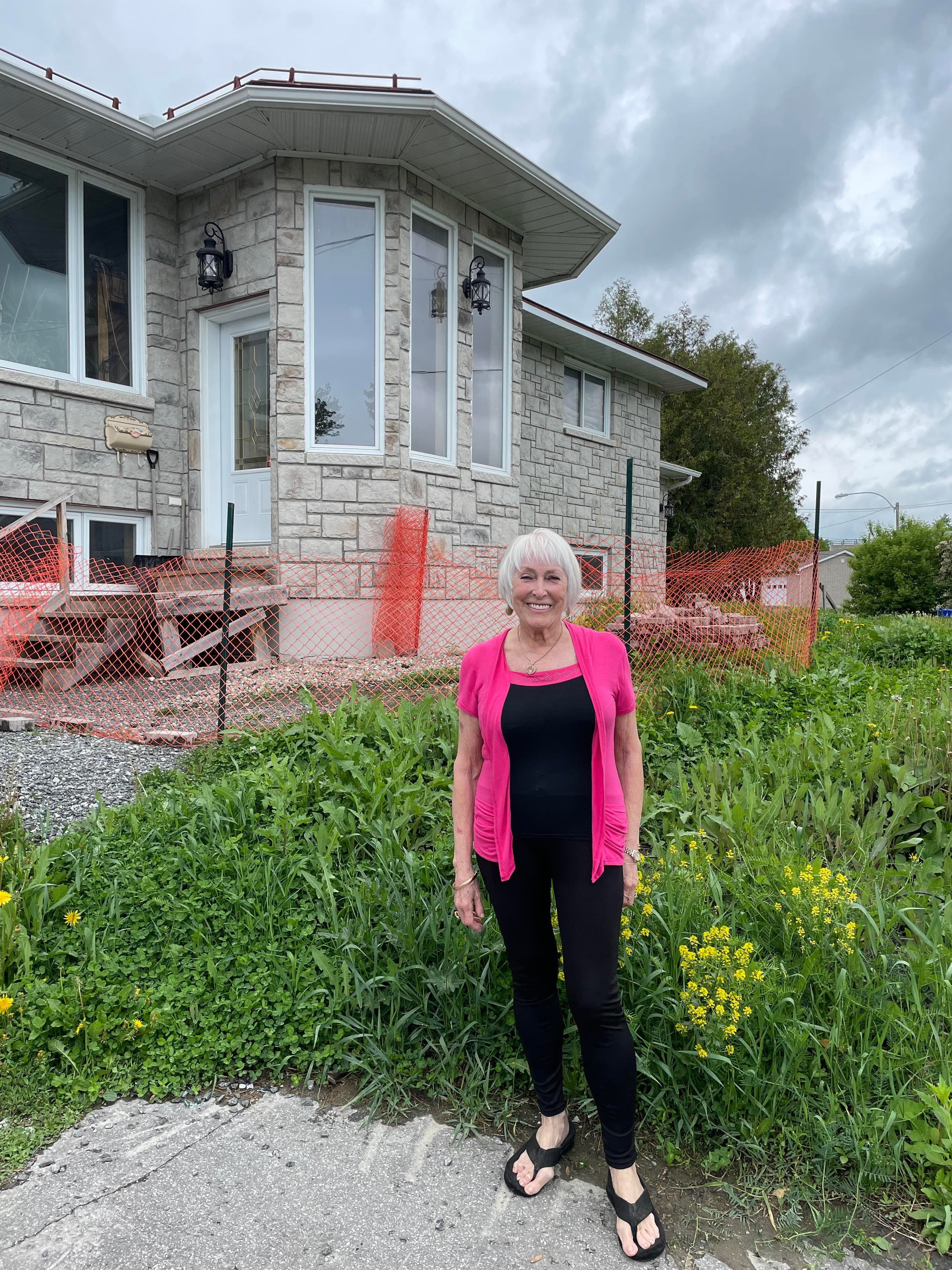 Candy Rochon, une résidente de Gatineau, devant sa maison située en zone inondable.