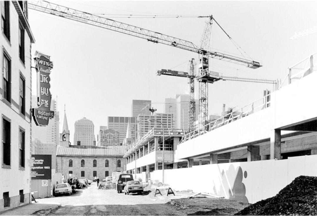 Le Complexe Guy-Favreau en construction, vu de la rue De La Gauchetière. En arrière-plan, l’église catholique du Quartier chinois est le seul lieu de culte préservé des démolitions.