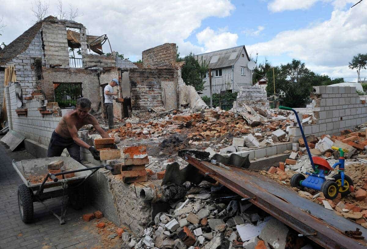 Un homme soulève des briques durant la reconstruction d'une maison détruite par la guerre dans la petite ville de Makariv, dans la région Kyïv.