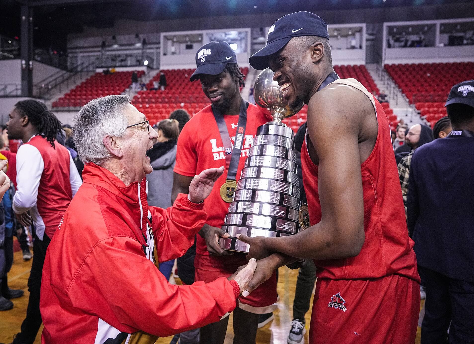 Saydou Sall et Massimo-Brandon Maniani-Wembe serrent la main de Jacques Paiement père.