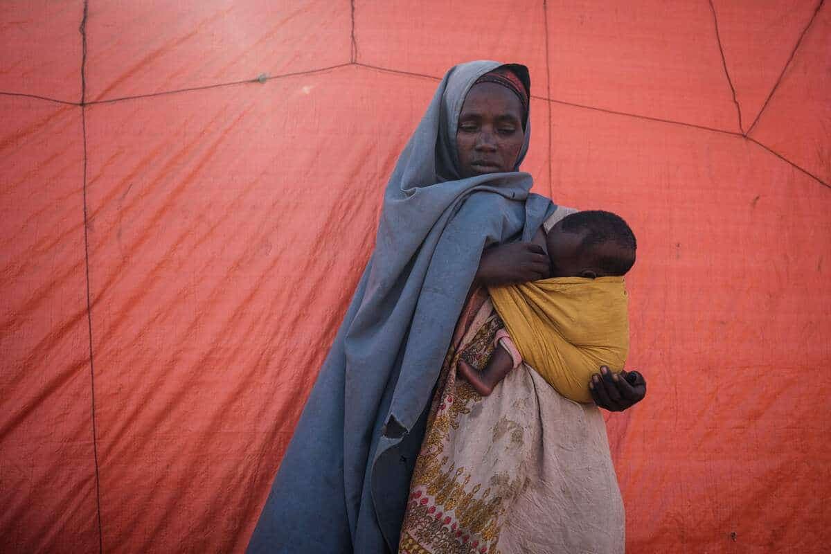 Hawa Adan Isack, 30 ans, tient son enfant dans le camp de Muuri pour les personnes déplacées, en Somalie.